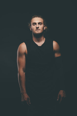 Portrait of a handsome athletic man posing over grunge background. Urban style.