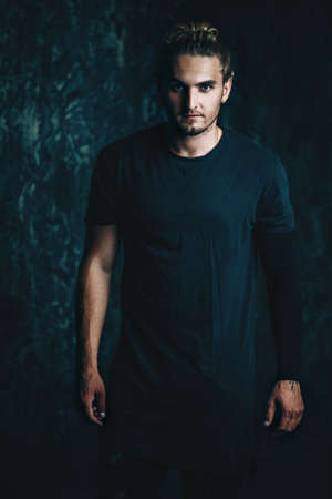 Portrait of a handsome athletic man posing over grunge background. Urban style.の写真素材