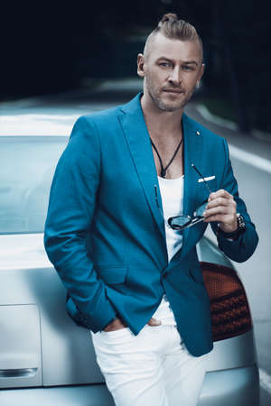 Modern mature man standing by his car. Business style. Vehicle concept. Luxury.の写真素材