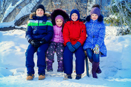 Happy children playing together outdoor on a sunny winter day. Snowfall. Winter clothes. Winter activity.の写真素材