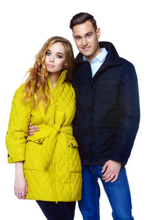 Fashion shot. Couple of young people in winter clothes posing at studio. Autumn and winter clothes.の写真素材