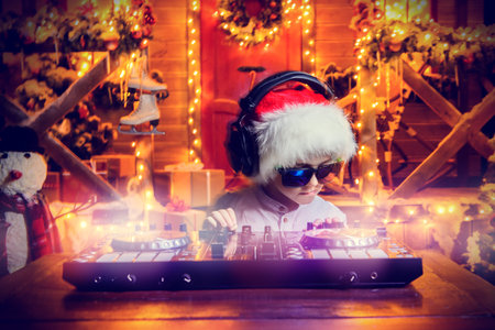 Little boy-DJ is having a party near the house of Santa Claus decorated with lights. Christmas party...