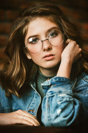 Portrait of a cute girl teenager wearing spectacles. Glasses for a modern young generation. Beauty, fashion.の写真素材