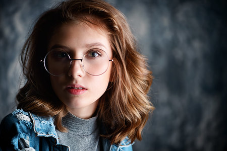 Portrait of a cute girl teenager wearing spectacles. Glasses for a modern young generation. Beauty,...