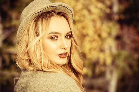 Beautiful fashion model posing in the autumn park. Autumn seasonal fashion.の写真素材