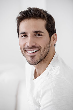 Happy young man looking at camera and smiling. Men's beauty and health.