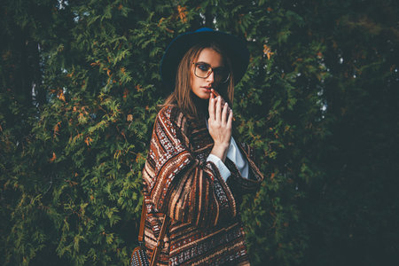 Fashion shot. Beautiful young woman in stylish clothes in the park. Ethnics, boho style.