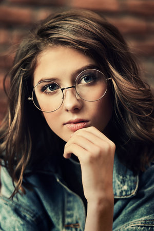 Portrait of a cute girl teenager wearing spectacles. Glasses for a modern young generation. Beauty,...