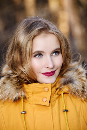 Girl walking in forest on winter day. Fashion shot. Down Jackets.の写真素材