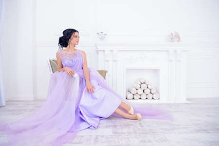 Full length portrait of a charming bride woman in a beautiful purple wedding dress. Luxurious apartments.の写真素材