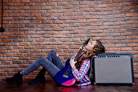 Portrait of an attractive girl with electric guitar. Rock music.の写真素材