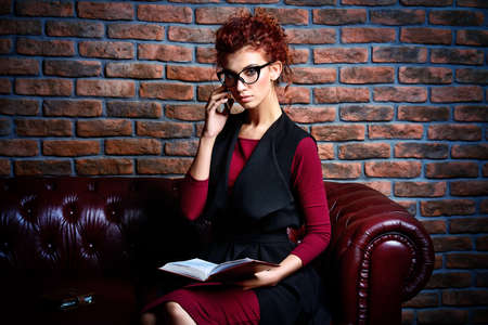 Elegant businesswoman  talking on her cell phone at the office. Contemporary business.の写真素材