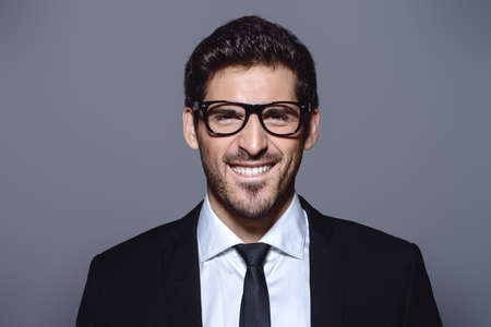 Portrait of a contemporary businessman in a suit looking at camera and smiling. の写真素材