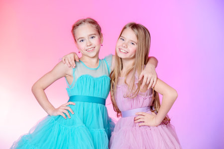 Two pretty little girls dressed in beautiful festive dresses.の写真素材