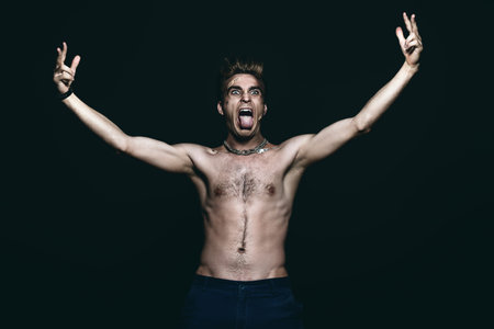 Bad boy concept. A portrait of a bad guy demonstrating antisocial behavior, rudeness and aggression. Rocker, punk. の写真素材