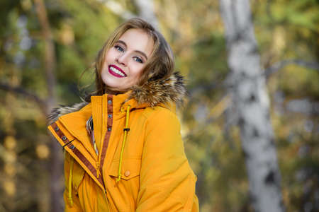 Girl walking in forest on winter day. Fashion shot. Down Jackets.の写真素材