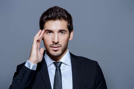 Portrait of a serious contemporary businessman in a suit. Studio shot.の写真素材