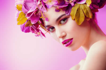 Beautiful romantic young woman in a wreath of flowers. Inspiration of spring and summer. Perfume, cosmetics concept.の写真素材