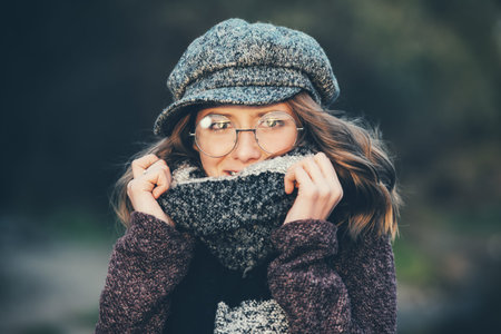 Cute teen girl in modern clothes posing outdoor. Warm autumn day. Seasonal autumn and winter fashion.の写真素材