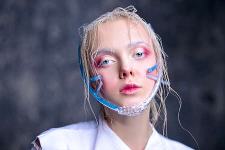 Ðrt fashion. Beautiful blonde girl with creative make-up and shiny healthy skin over dark background.  の写真素材