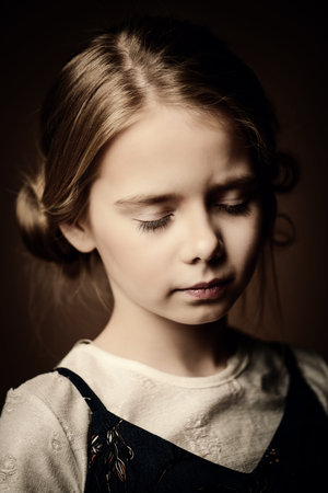 Portrait of a beautiful eight year old girl with calm pensive look. Childhood concept. 