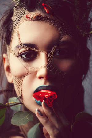 Spring Fantasy. Young woman looks like a beautiful forest nymph with green leaves and bright makeup. Cosmetics and make-up concept.の写真素材