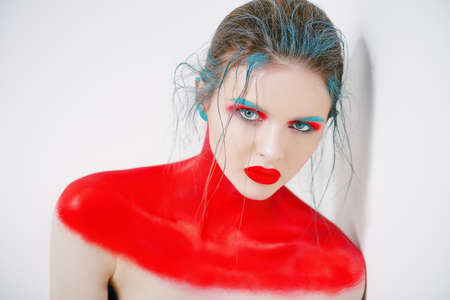 Portrait of a beautiful young woman with creative makeup and body painting. White background. Fashion and make-up concept.の写真素材
