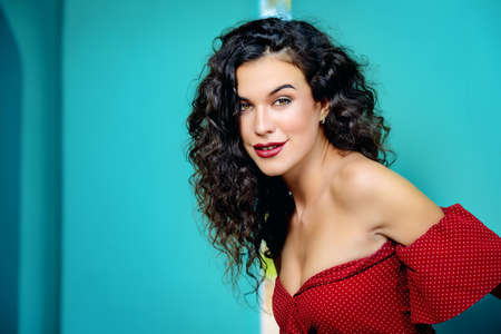 Charming young woman dressed in elegant burgundy dress on a city street. Beauty, fashion concept. Cosmetics and make-up.の写真素材