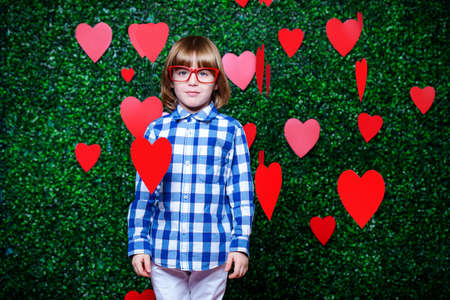 Ð¡ute child boy surrounded by hearts over lawny background. First love. Valentine's Day. の写真素材