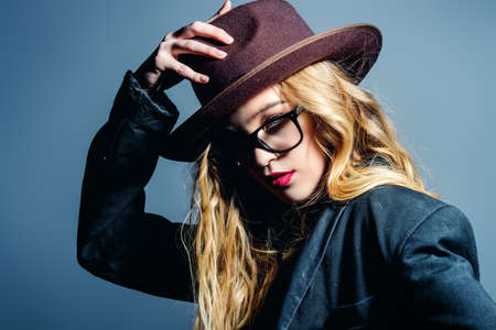 Attractive fashionable young woman wearing in hat and glasses. Optics style. Studio shot.の写真素材