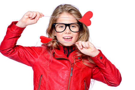 Portrait of a cute pre-teen girl holding two little hearts. Isolated over white. First love. Valentine's Day. の写真素材