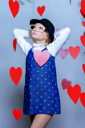 Valentine's Day concept. Happy pre-teen girl poses surrounded by little hearts. First love.の写真素材