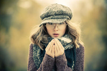 Cute teen girl in modern clothes posing outdoor. Warm autumn day. Seasonal autumn and winter fashion.の写真素材