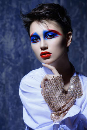 Fashion and make-up concept. Close-up portrait of an attractive young woman with creative makeup and body painting.の写真素材