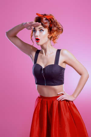 Pretty charming girl looks at something in the distance. Pin-up style. Bright make-up. Beauty, cosmetics.の写真素材