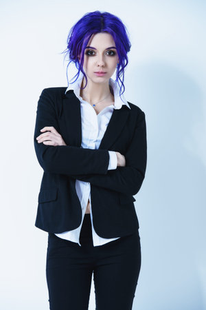 Portrait of the attractive young woman with bright purple hair and elegant suit over white...