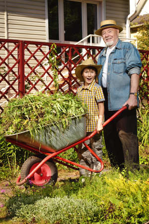 Happy grandpa and his grandson gardening together.の写真素材