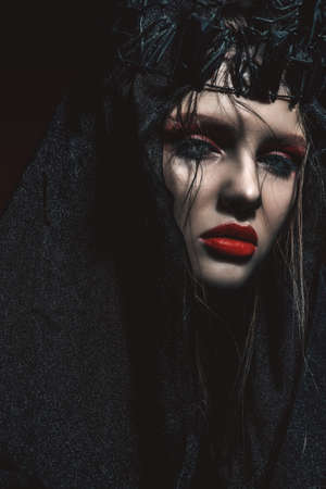 Portrait of a beautiful black princess with creative vivid makeup dressed in a black crown and veil. Fashion and make-up concept. の写真素材