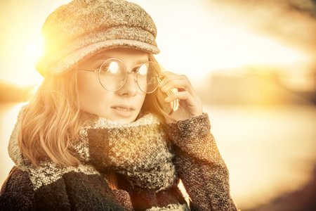 Cute teen girl in modern clothes posing outdoor. Warm autumn day. Seasonal autumn and winter fashion.の写真素材