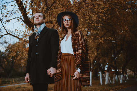 Portrait of a beautiful young people walking in the autumn park. Autumn fashion. の写真素材
