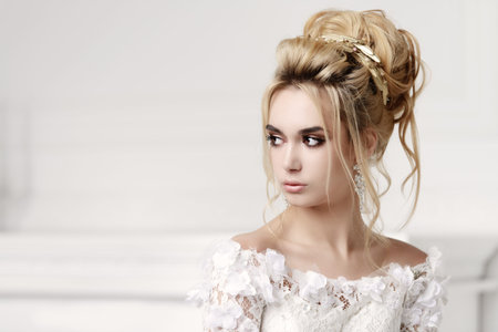 Close-up portrait of a beautiful bride woman. Wedding make-up and hairstyle. Jewellery.の写真素材
