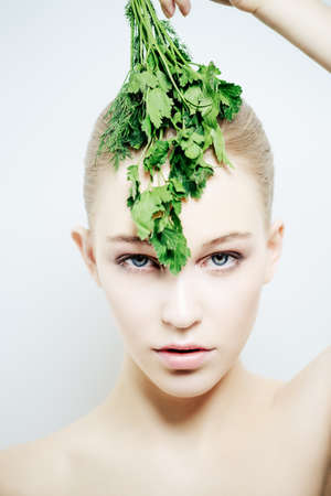 Beautiful young woman with bunch of parsley. Beauty, natural cosmetics concept. Spa, body care.の写真素材
