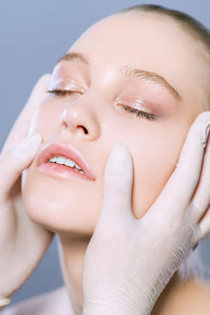 Portrait of a beautiful young woman with a facial massage. Beauty, skincare cosmetology.の写真素材