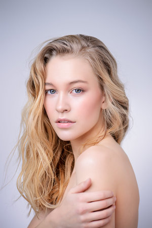 Portrait of a beautiful blonde woman with natural make-up. Beauty, haircare, cosmetics concept. Healthcare. White background.の写真素材