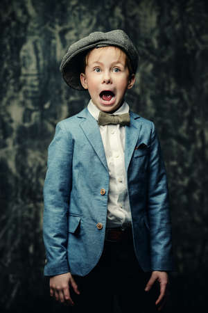 Kid's fashion. Happy child boy posing at studio in elegant clothes. Clothes for children. の写真素材