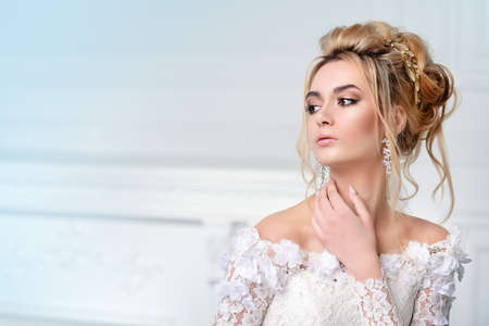 Close-up portrait of a beautiful bride woman. Wedding make-up and hairstyle. Jewellery.の写真素材