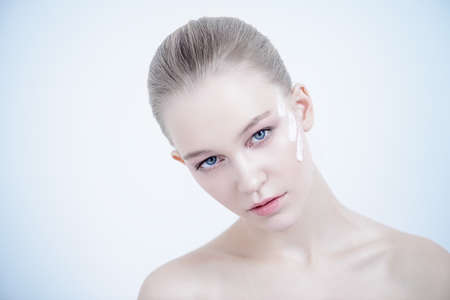 Close-up portrait of a beautiful girl with cream on her face. Beauty, fashion. Skincare, healthcare. Spa for women.の写真素材