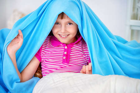 Happy smiling child girl having a rest at home. Happy childhood.の写真素材
