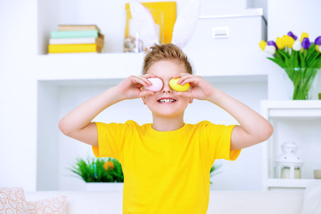 Easter holidays. Funny happy boy wearing bunny ears celebrating Easter at home.