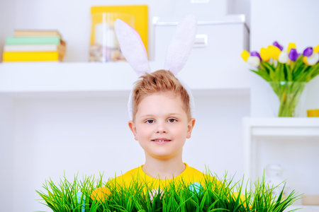 Easter holidays. Funny happy boy wearing bunny ears celebrating Easter at home.